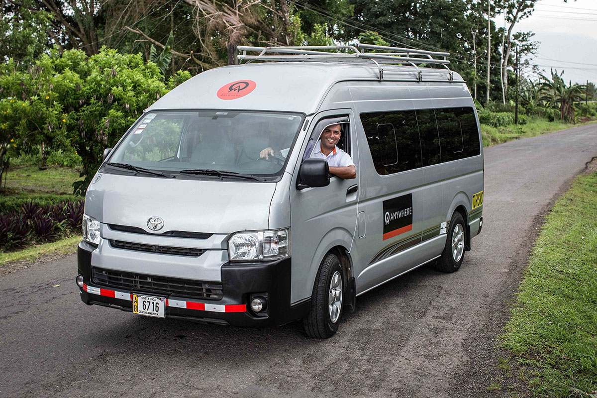 A friendly driver smiles from an Anywhere van